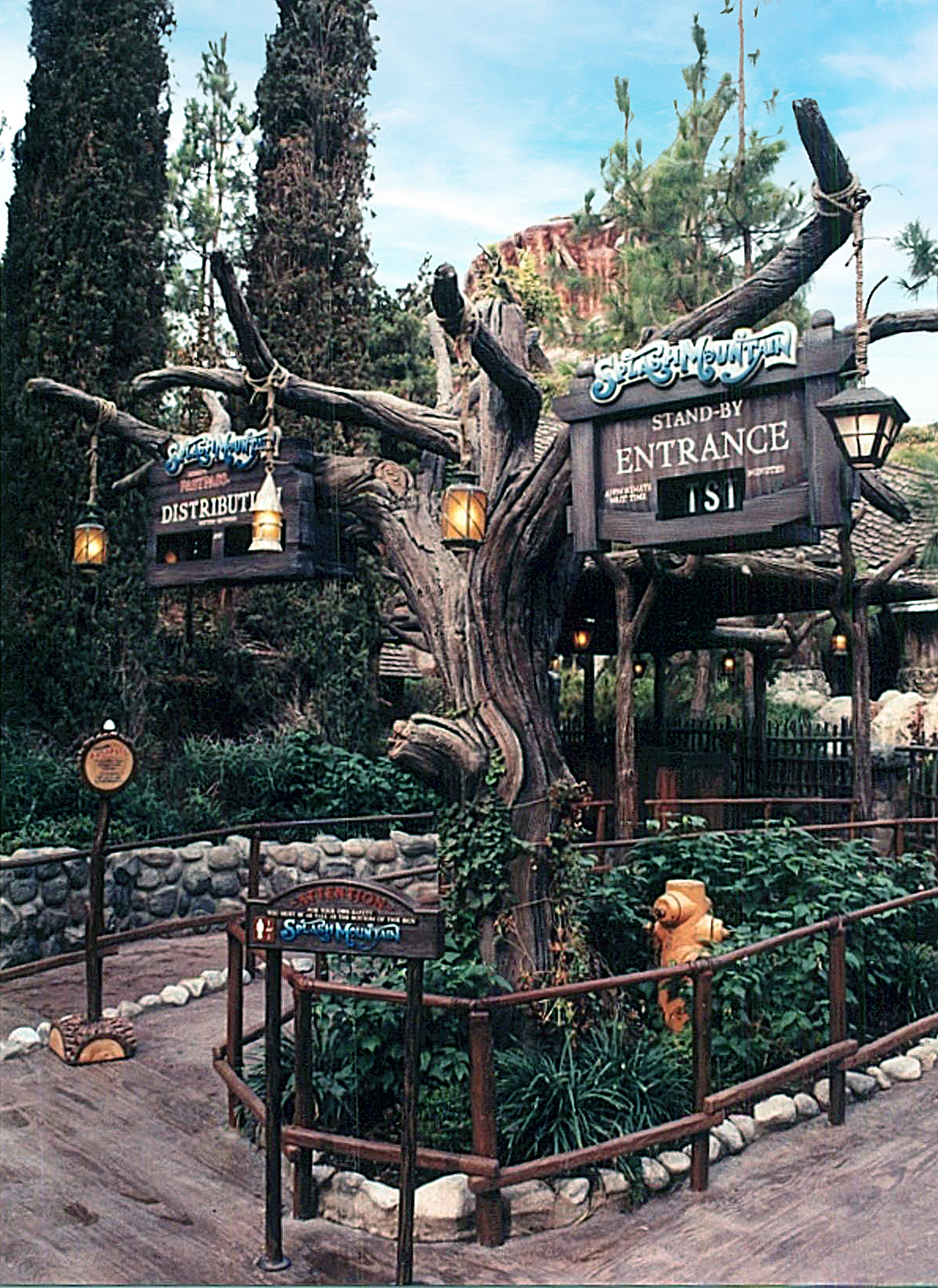 Themed attraction entrance with sculpted dead tree signage
