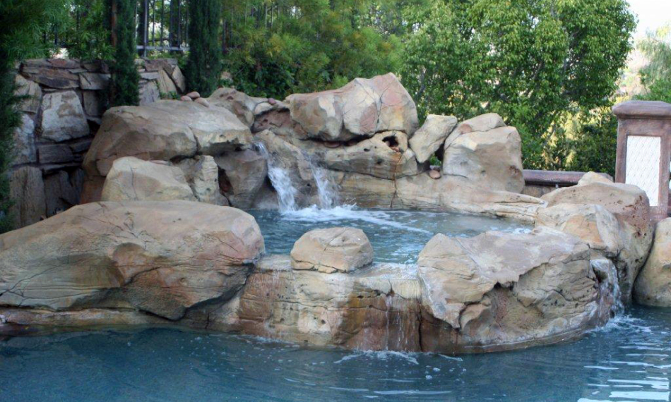 Pool waterfall with tan concrete rocks