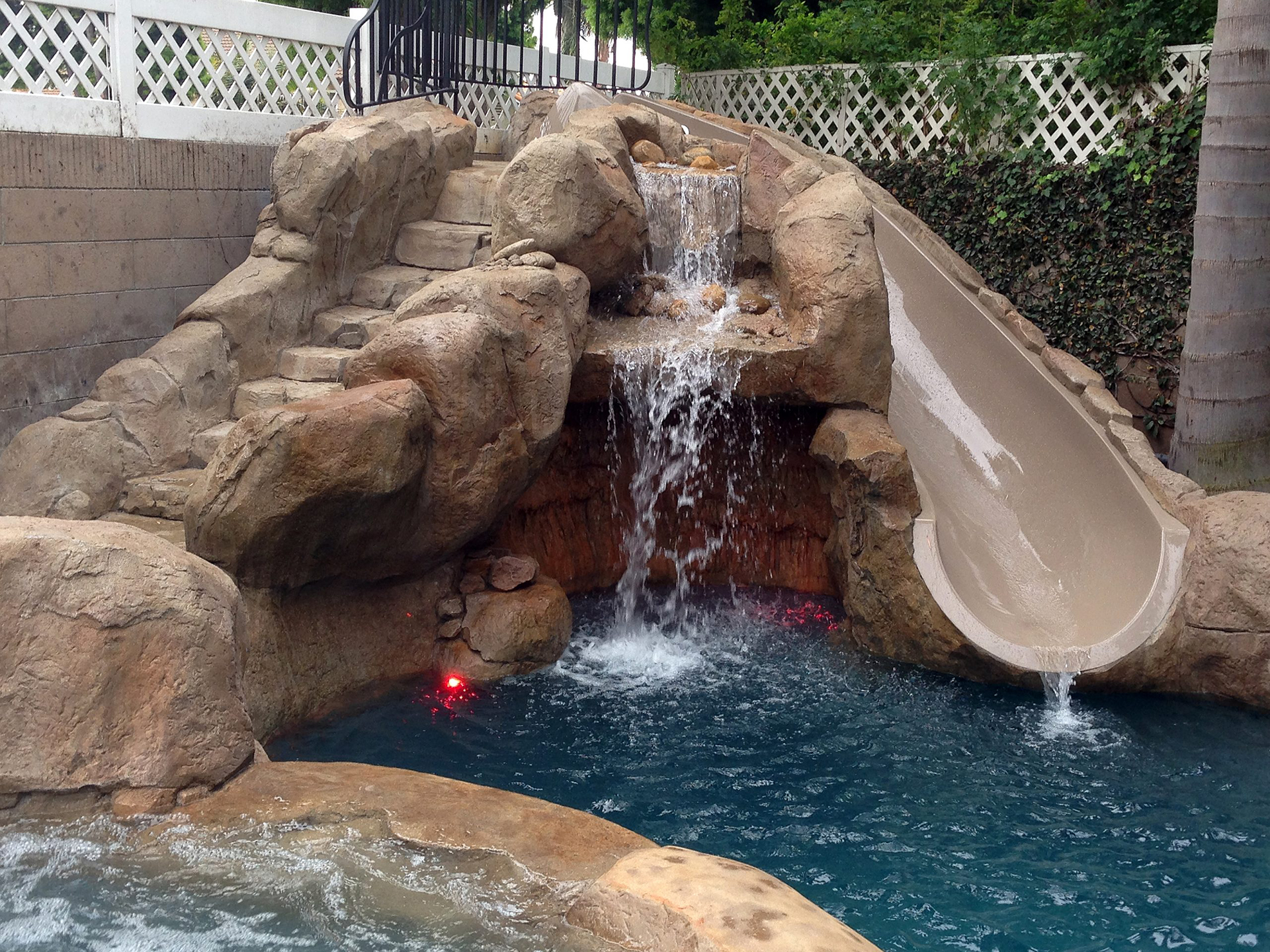 Grotto with illuminated cave interior and water slide